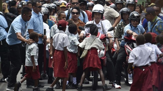 Presiden Joko Widodo membonceng istrinya, Iriana di atas skuter listrik ketika berkunjung ke Kampung Kaye, Distrik Agats, Kabupaten Asmat, Papua, Kamis (12/4). [Antara/Puspa Perwitasari]