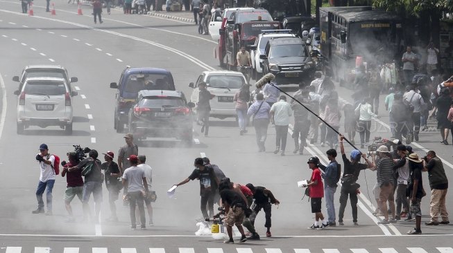 Suasana di Jalan MH Thamrin, tepatnya di depan gedung Sarinah, ketika digunakan untuk kegiatan syuting film berdasarkan peristiwa Bom Thamrin, di Jakarta, Sabtu (14/4/2018). [Suara.com/Kurniawan Mas'ud]