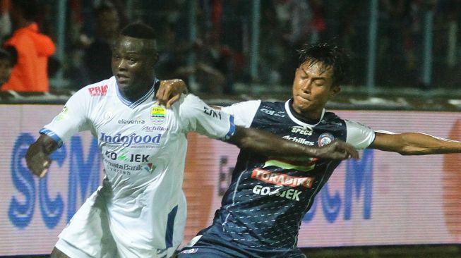 Pesepakbola Persib Bandung, Ezechiel Ndouasel (kiri) berebut bola dengan pesepakbola Arema FC, Johan Al Farisyi (kanan) dalam pertandingan GO-JEK Liga I di Stadion Kanjuruhan, Malang, Jawa Timur, Minggu (15/4). Skor di akhir babak pertama 1-1. ANTARA