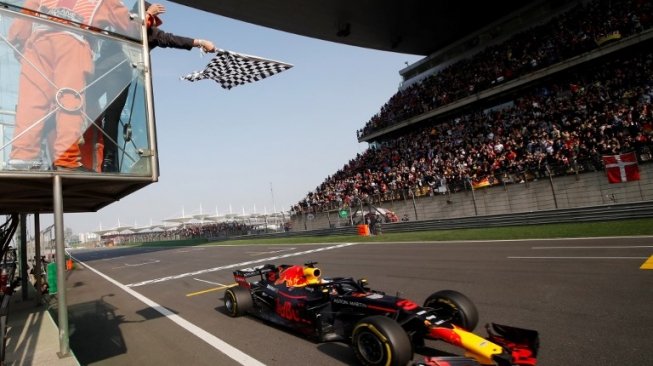 Pebalap Red Bull Racing, Daniel Ricciardo, melintasi garif finis pertama di F1 GP Cina, Minggu (15/4/2018). [AFP]