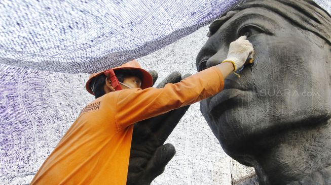 Pekerja melakukan perawatan patung Jenderal Sudirman di Jakarta, Senin (16/4/2018). [suara.com/Oke Atmaja]