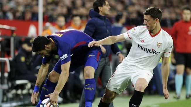 Bek Sevilla Clement Lenglet (kanan) berebut bola dengan striker Barcelona Luis Suarez. Cristina Quicler / AFP 