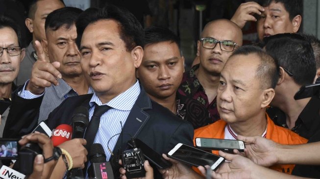 Mantan Kepala Badan Penyehatan Perbankan Nasional (BPPN) Syafruddin Arsyad Temenggung (kanan) diwakili kuasa hukumnya Yusril Ihza Mahendra (kiri) menjawab pertanyaan wartawan seusai menandatangani berkas pelimpahan tahap dua di gedung KPK, Jakarta, Rabu (18/4).