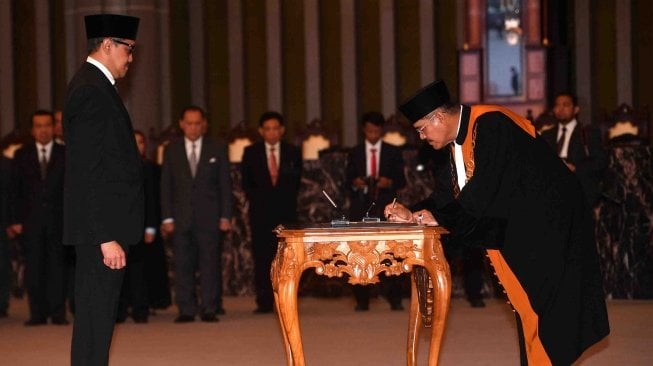 Ketua Mahkamah Agung M Hatta Ali (kanan) menangatanganni berita acara pelantikan Deputi Gubernur Bank Indonesia (BI) Dody Budi Waluyo (kiri) di Mahkamah Agung, Jakarta, Rabu (18/4). 