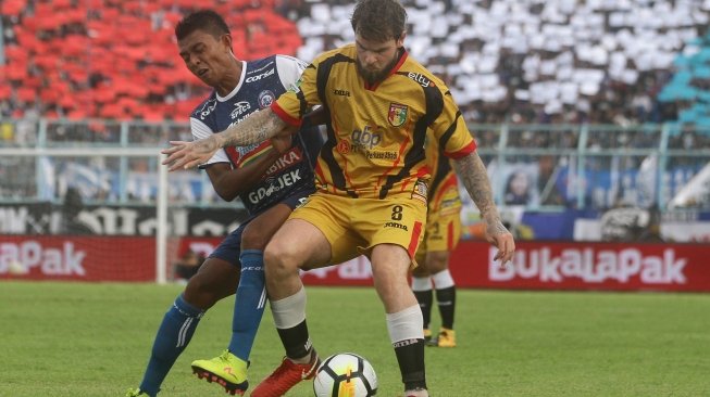 Pemain Arema FC, Dedik Setiawan (kiri) berusaha merebut bola dari pesepakbola Mitra Kukar, Danny Guthrie (kanan) dalam pertandingan Liga I di Stadion Kanjuruhan, Malang, Jawa Timur, Sabtu (24/3). ANTARA FOTO/Ari Bowo Sucipto