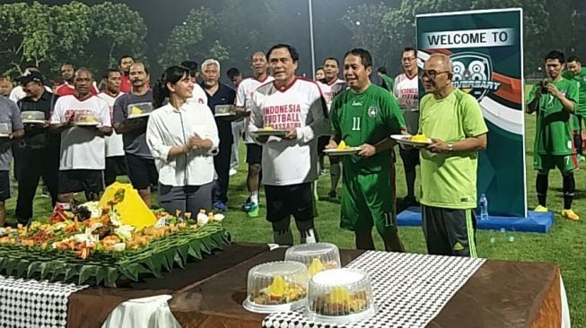 Perayaan Hut PSSI yang ke-88 di lapangan ABC, Senayan, Jakarta, Kamis (19/4/2018). Sekjen PSSI Ratu Tisha Destria memberikan potongan tumpeng kepada Plt Ketua Umum Joko Driyono dan legenda timnas Indonesia. (Suara.com/Adie Prasetyo) 