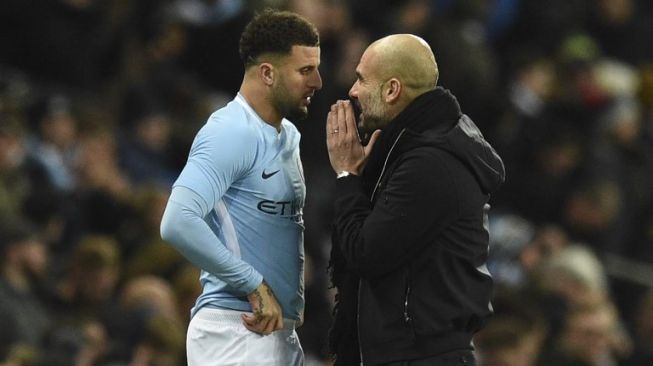 Manajer Manchester City Pep Guardiola (kanan) berbicara dengan pemainnya Kyle Walker. Oli SCARFF / AFP