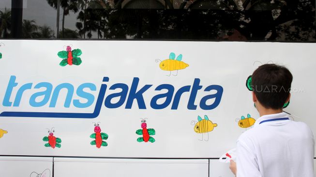 Anak-anak berkebutuhan khusus melukis di dinding bus transjakarta di depan Pendopo Balai Kota DKI Jakarta, Jumat (20/4).