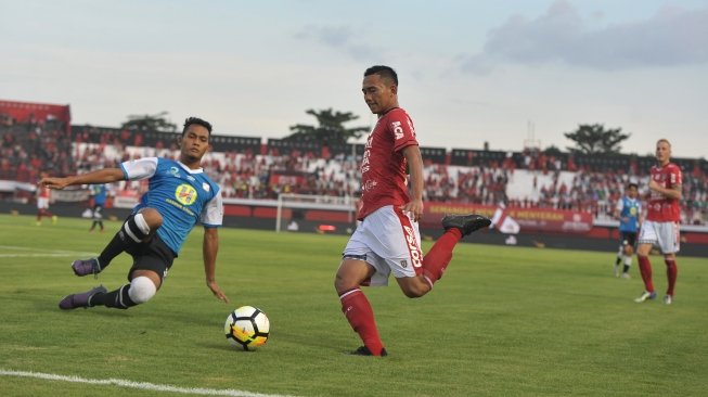 Pesepak bola Bali United Ricky Fajrin (kedua kiri) berupaya melewati pesepak bola Barito Putra Dandi Maulana Abdulhak dalam Pertandingan Sepak Bola Liga 1 2018 di Stadion I Wayan Dipta, Gianyar, Bali, Minggu (22/4). Bali United menang atas Barito Putra dengan skor 2-0. ANTARA