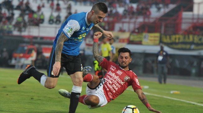 Pesepak bola Barito Putra Aaron Michael Evans (kiri) dihadang pesepak bola Bali United Stefano Lilipaly dalam Pertandingan Sepak Bola Liga 1 2018 di Stadion I Wayan Dipta, Gianyar, Bali, Minggu (22/4). Bali United menang atas Barito Putra dengan skor 2-0. ANTARA