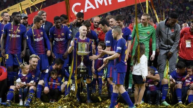 Pemain Barcelona Andres Iniesta mengangkat trofi Copa del Rey usai timnya mengalahkan Sevilla 5-0 di partai final yang digelar di Estadio Wanda Metropolitano [AFP]