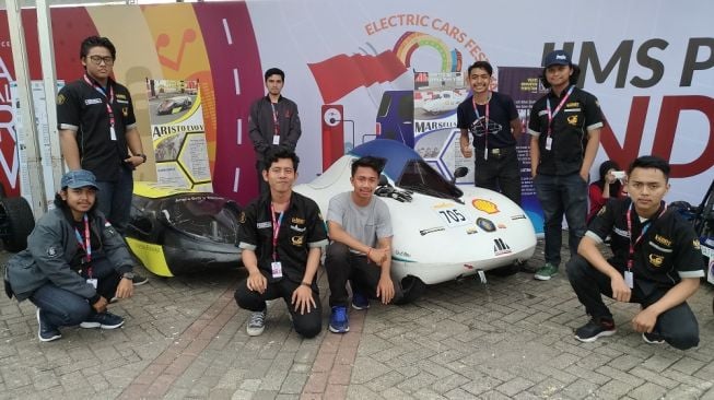 Para mahasiswa Universitas Brawijaya berfoto bersama mobil-mobil listrik mereka di IIMS 2018, Jakarta, Sabtu (21/4). [Suara.com/Manuel Jeghesta Nainggolan]