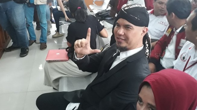 Ahmad Dhani mengenakan setelan jas dan belangkon dalam sidang ujaran kebencian di PN Jakarta Selatan, Senin (23/4/2018). (Wahyu Tri Laksono/Suara.com)