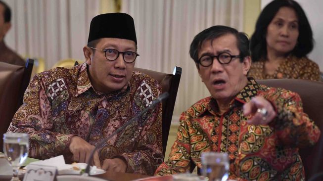 Menteri Agama Lukman Hakim Saifuddin (kiri) berbincang dengan Menkumham Yasonna Laoly (kanan) sebelum mengikuti rapat terbatas tentang pengelolaan dana haji di Istana Bogor, Jawa Barat, Kamis (26/4).