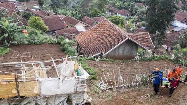 Relawan yang tergabung dalam tim gabungan melakukan evakuasi korban bencana gempa saat simulasi gempa bumi di kawasan Tebing Keraton, Ciburial, Kabupaten Bandung, Jawa Barat, Kamis (26/4). 