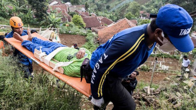 Relawan yang tergabung dalam tim gabungan melakukan evakuasi korban bencana gempa saat simulasi gempa bumi di kawasan Tebing Keraton, Ciburial, Kabupaten Bandung, Jawa Barat, Kamis (26/4). 