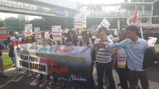 Puluhan pendemo meminta polisi untuk mengusut laporan kasus penyebaran berita bohong yang diduga dilakukan Fahri Hamzah dan Fadli Zon. (Agung Sandy Lesmana/Suara.com)