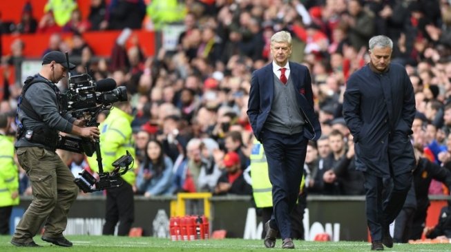 Manajer Arsenal Arsene Wenger (kiri) berjalan berdampingan dengan manajer Manchester United Jose Mourinho usai pertandingan di Old Trafford yang dimenangkan oleh tuan rumah 2-1 [AFP]