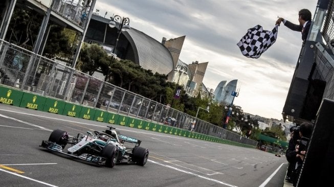 Pebalap Mercedes Lewis Hamilton melintasi garis finis pertama di seri keempat F1 GP Azerbaijan di Sirkuit Baku, Minggu (29/4/2018). [AFP/Srdjan Suki]