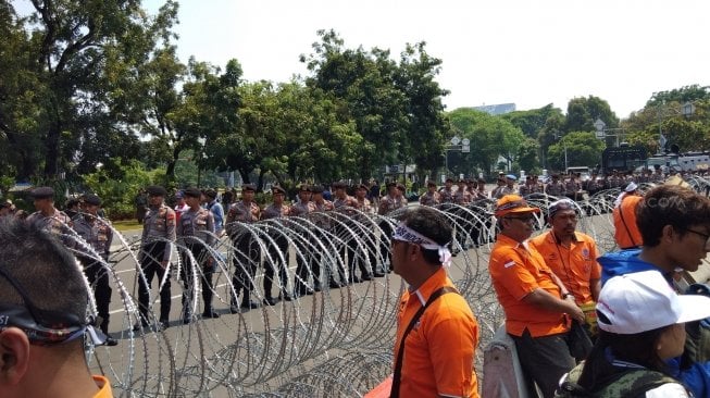 Polisi memasang kawat berduri di depan Istana Merdeka, Medan Merdeka Utara, Jakarta Pusat. (Suara.com/Ria Rizki)