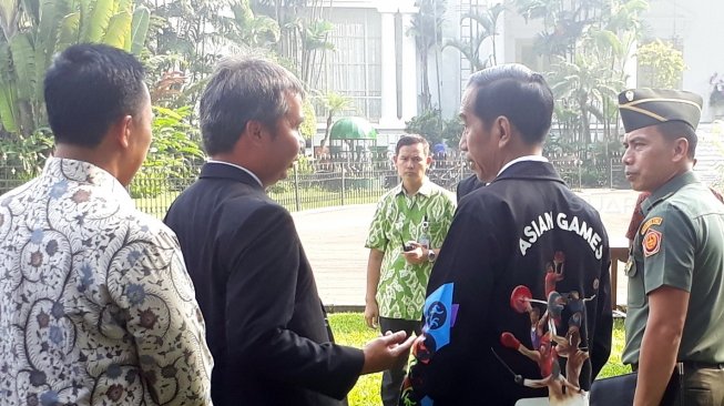 Presiden Joko Widodo (Jokowi) memakai jaket Asian Games 2018 di Istana Kepresidenan Bogor, Jawa Barat, Kamis (3/5/2018). [Suara.com/Dwi Bowo Raharjo]