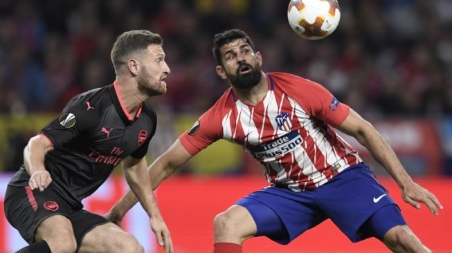 Pemain Arsenal Shokdran Mustafi berebut bola dengan pemain Atletico Diego Costa di leg kedua semifinal Liga Europa yang digelar di Estadio Wanda Metropolitano, Jum'at (4/5/2018) [AFP]