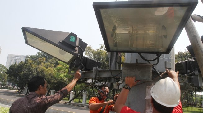 Petugas Dinas Penerangan Jalan Umum melakukan perawatan lampu di Jalan Merdeka Barat, Jakarta, Sabtu (5/5)