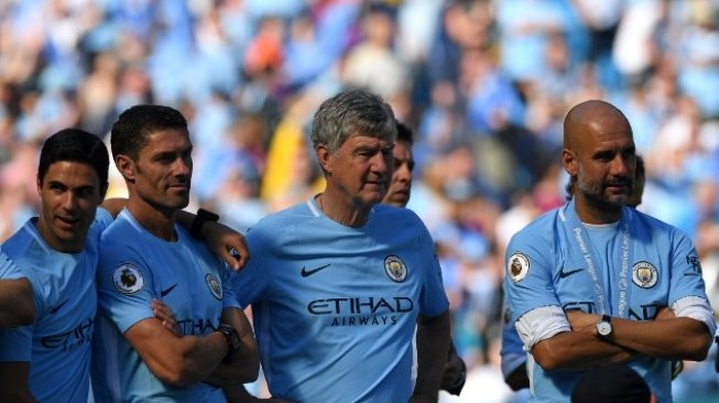 Manajer Man City Josep Guardiola menyaksikan perayaan gelar juara The Citizens di Etihad Stadium usai bermain imbang kontra Huddersfield Town, Minggu (6/5/2018) [AFP]