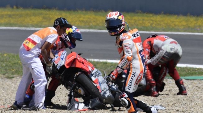 Pebalap Repsol Honda Dani Pedrosa meninggalkan arena setelah terlibat kecelakaan dengan dua pebalap lainnya [AFP]