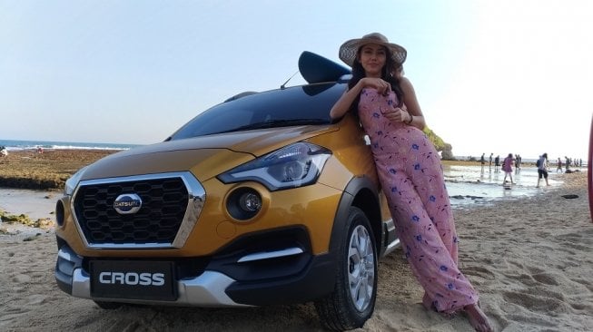 Seorang model berfoto di depan sebuah Datsun Cross di Pantai Ngandong, Wonosari, Yogyakarta pada awal Mei 2018. [Suara.com/Manuel Jeghesta Nainggolan]