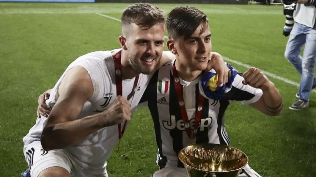 Penyerang Juventus, Paulo Dybala (kanan) merayakan gelar juara Coppa Italia bersama rekan setimnya, Miralem Pjanic (AFP/ISABELLA BONOTTO)