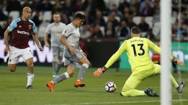 Striker Manchester United Alexis Sanchez (tengah) membawa bola mencoba mengancam gawang kiper West Ham United Adrian. Ian KINGTON / AFP