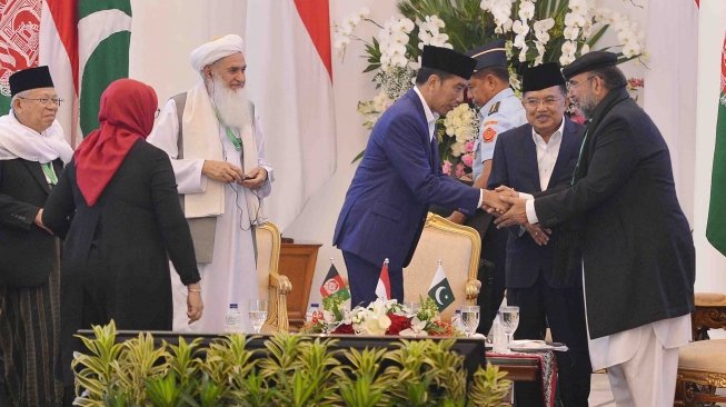 Presiden Joko Widodo (tengah) berjabat tangan dengan Ketua Dewan Ideologi Islam Pakistan Qiblq Ayaz (kanan) disaksikan Wakil Presiden Jusuf Kalla (kedua kanan) Menlu Retno L.P Marsudi (kedua kiri), Ketua MUI Ma'ruf Amin (kiri) dan Kepala Dewan Ulama Afganistan Qiamuddin Kashaf (ketiga kiri) seusai membuka pertemuan trilateral ulama Indonesia, Pakistan dan Afganistan di Istana Bogor, Jawa Barat, Jumat (11/5). 