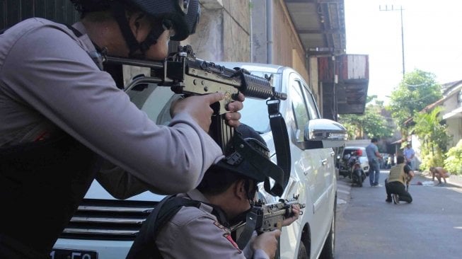 Polisi menghentikan dan memeriksa warga yang melintas di Jalan Niaga Samping setelah terjadi ledakan di Polrestabes Surabaya, Jawa Timur, Senin (14/5). 