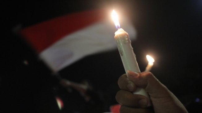 Warga menyalakan lilin saat aksi lilin kebersamaan Suroboyo Wani di Tugu Pahlawan, Surabaya, Jawa Timur, Minggu (13/5). Aksi yang diikuti ratusan orang dari berbagai lapisan itu mengecam aksi terorisme bom bunuh diri yang terjadi di Surabaya. ANTARA