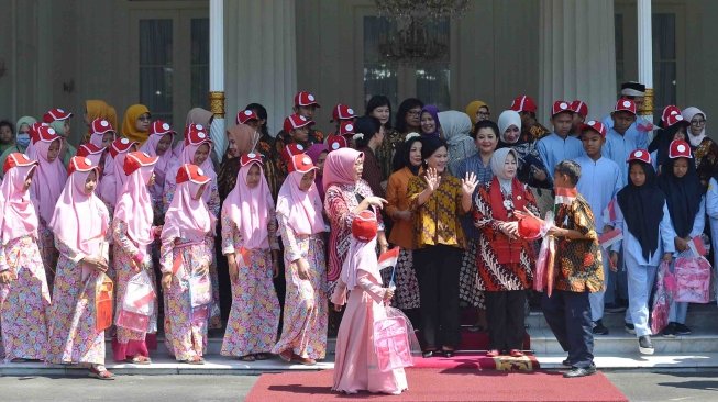 Ibu Negara Iriana Joko Widodo (tengah) beserta anggota Organisasi Aksi Solidaritas Era Kabinet Kerja (OASE-KK) bersiap melakukan foto bersama dengan anak-anak seusai acara bergembira bersama ibu negara di Gedung Agung Yogyakarta, Senin (14/5). 