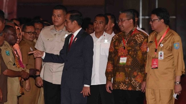 Presiden Joko Widodo (tengah) didampingi Menteri Dalam Negeri Tjahjo Kumolo (kanan) dan Menteri Desa, Pembangunan Daerah Tertinggal dan Transmigrasi Eko Putro Sandjojo (kedua kanan) menghadiri Pembukaan Rapat Koordinasi Nasional Pembinaan Penyelenggaraan Pemerintahan Desa, Pusat dan Daerah Tahun 2018 di Jakarta, Senin (14/5).