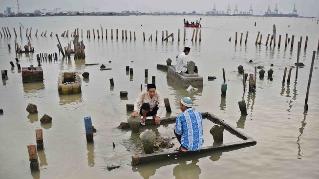 Warga berziarah di makam kerabatnya di tempat pemakaman umum (TPU) yang terdampak abrasi di Tambaklorok, Semarang, Jawa Tengah, Rabu (16/5). 