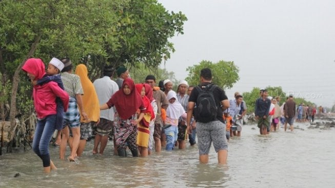 Warga berziarah di makam kerabatnya di tempat pemakaman umum (TPU) yang terdampak abrasi di Tambaklorok, Semarang, Jawa Tengah, Rabu (16/5/2018). [Suara.com/Adam Iyasa]