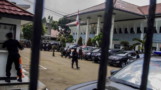 Petugas kepolisian berjaga saat sidang kasus terorisme dengan terdakwa Aman Abdurrahman alias Oman Rochman alias Abu Sulaiman bin Ade Sudarma di PN Jakarta Selatan, Jakarta, Jumat (18/5).