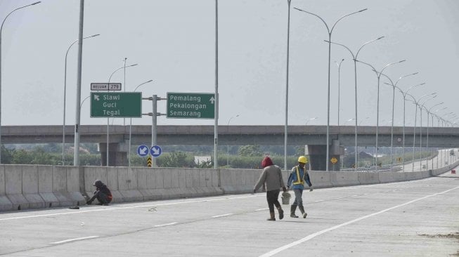 Pekerja mengerjakan pembatas jalan pada ruas Tol Pejagan-Pemalang di Tegal, Jawa Tengah, Jumat (18/5).