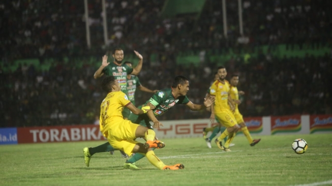 Pemain PSMS Medan (hijau) dan Sriwijaya FC berduel memperebutkan bola dalam lanjutan kompetisi Liga 1 di Stadion Teladan, Medan, Sumatera Utara, Jumat malam (18/5). [Suara.com/Dhiko Tungga Alam]