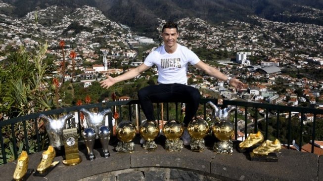 Pemain Real Madrid Cristiano Ronaldo berpose dengan sebagian kecil trofi yang dimenangkannya selama berkarier sebagai pesepak bola profesional [AFP]