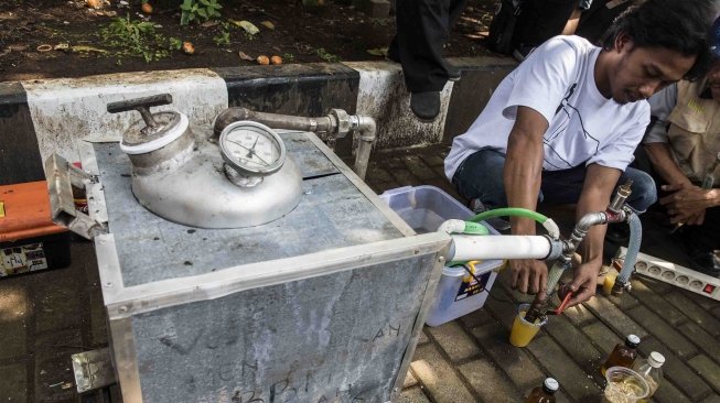 Aktivis Gerakan Tarik Plastik (Get Plastic) menunggu hasil pembakaran plastik dari mesin GP 007 untuk dijadikan bahan bakar minyak jenis premium saat pelatihan dan sosialisasi pengolahan sampah plastik di Bandung, Jawa Barat, Senin (21/5). 