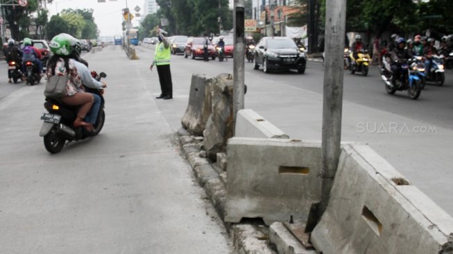 Petugas Kepolisian bersama petugas Dinas Perhubungan mengatur lalu lintas di tiga persimpangan Jalan Mampang Prapatan, Jakarta Selatan, Senin (21/5). 