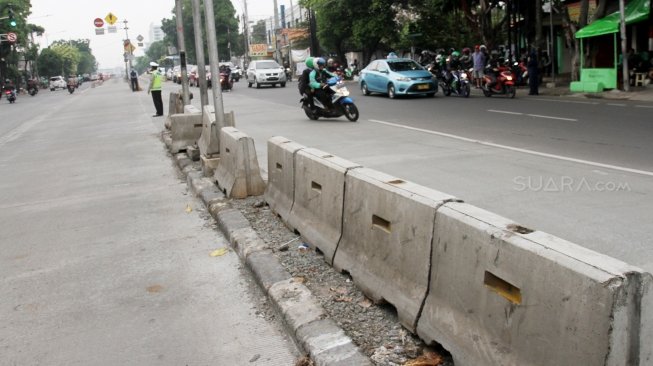 Petugas Kepolisian bersama petugas Dinas Perhubungan mengatur lalu lintas di tiga persimpangan Jalan Mampang Prapatan, Jakarta Selatan, Senin (21/5). 