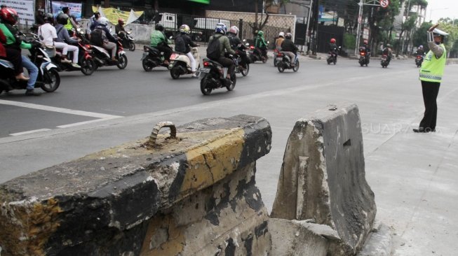 Petugas Kepolisian bersama petugas Dinas Perhubungan mengatur lalu lintas di tiga persimpangan Jalan Mampang Prapatan, Jakarta Selatan, Senin (21/5). 