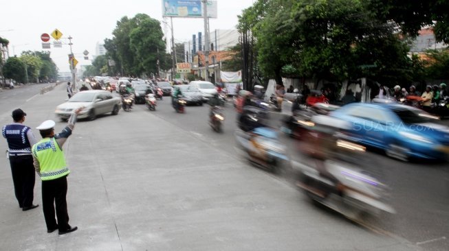 Petugas Kepolisian bersama petugas Dinas Perhubungan mengatur lalu lintas di tiga persimpangan Jalan Mampang Prapatan, Jakarta Selatan, Senin (21/5). 