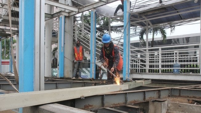 Sejumlah pekerja membongkar halte TransJakarta BNN di kawasan Cawang, Jakarta, Rabu (23/5).