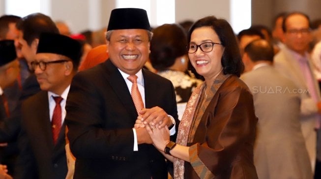 Menteri Keuangan Sri Mulyani (kanan) memberikan ucapan selamat kepada Gubernur Bank Indonesia Perry Warjiyo (kiri) usai pengucapan sumpah jabatan pelantikan di Mahkamah Agung, Jakarta, Kamis (24/5). 